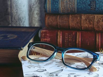 Close up of a book and glasses on wooden table